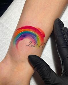 a person with a rainbow tattoo on their arm