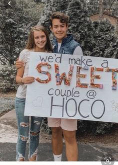 two people standing next to each other holding a sign that says we'd make a sweet couple at hoco