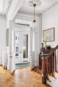 an entryway with wooden floors and white walls, decorated in wood trimmings