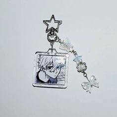 a keychain with an anime character and a star charm on it's side