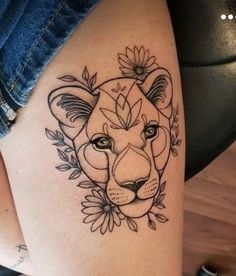 a woman's thigh with a tattoo on it and a lion head in the middle