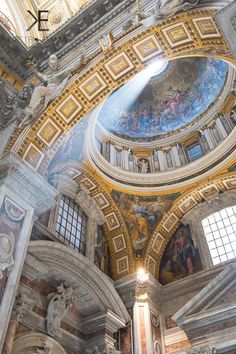 the inside of an ornate building with paintings on it's ceiling and windows above