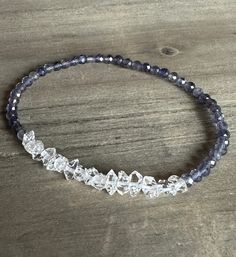 This gorgeous bracelet features Genuine Sparkling Herkimer Diamond Quartz and shaded Iolite faceted round beads, strung with strong elastic cord for flexibility and comfort. Herkimer Diamond Quartz measures 4-5mm Iolite measures 3mm You can customize your bracelet by choosing your desired length and finish from the drop-down menu.