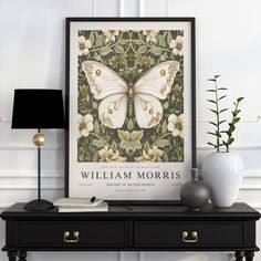 a white butterfly on a green background in a frame next to a lamp and vase