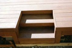 a wooden bench sitting on top of a cement ground next to a building with no doors