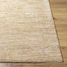 a beige area rug on top of a wooden floor