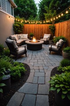 an outdoor fire pit surrounded by seating and lights