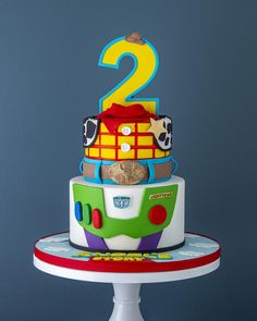 a birthday cake for two year old boy with toy cars and numbers on the top