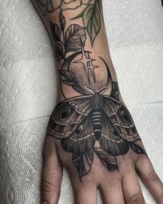 a person's hand with a tattoo on it and a butterfly in the middle