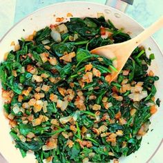 a white bowl filled with spinach and onions