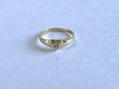 This cute small 14K gold heart signet ring is the perfect size for a baby, child, or pinky ring for women. The center stone is a simulated pink diamond (Cubic Zirconia). The ring is made of 100% 14K gold. It's a beautiful ring for a little girl or a gorgeous pinky ring. Ring is shown on a small child's hand Stamped 14K gold Cubic Zirconia Stone Small sized ring Visit us on Instagram @agoldmindjewelry for our custom jewelry designs and newest listings ▬ All jewelry pieces are sent in a gift box ▬ 14k Gold Heart Ring With Single Diamond For Gift, Gold Heart Ring With Single Diamond As Gift, Dainty Heart Shaped Birthstone Ring, Dainty Heart Ring With Birthstone For Valentine's Day, Dainty Heart-shaped Birthstone Ring For Valentine's Day, Classic 14k Gold Heart-shaped Birthstone Ring, Dainty Yellow Gold Heart Ring With Birthstone, Dainty Yellow Gold Heart Birthstone Ring, 14k Gold Dainty Birthstone Ring For Valentine's Day