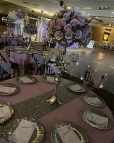 the table is set with silver and gold plates, napkins, and centerpieces