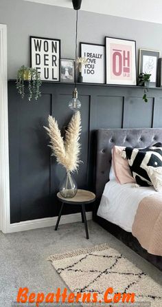 a bedroom with gray walls and pictures on the wall above the bed, along with a rug