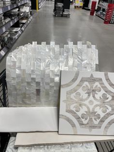 some white and grey tile in a store aisle with other items on the shelves behind them