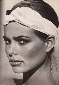 a black and white photo of a woman with a towel on her head wearing a turban