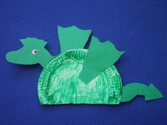 a paper plate shaped like a fish on a blue surface with the shape of a turtle cut out