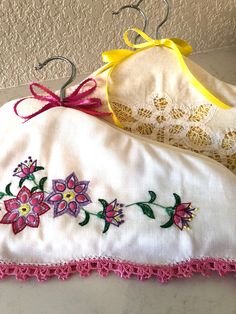 two white pillows with pink and yellow flowers on them