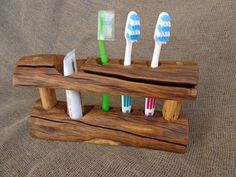 four toothbrushes are placed in a wooden holder