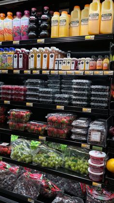 a display in a grocery store filled with lots of fruit and juices for sale