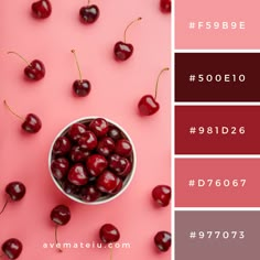 a bowl filled with cherries on top of a pink table