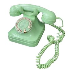 an old - fashioned green phone is on display against a white background with the cord still attached