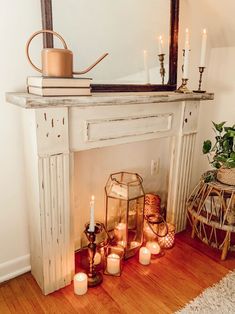 a fireplace with candles and a mirror above it