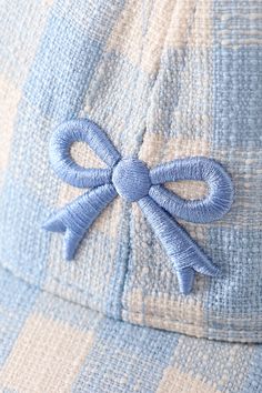 a blue bow is on the back of a baseball cap that has been embroidered onto it