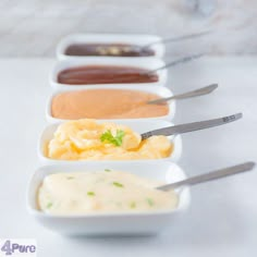 four different sauces in small white dishes with spoons on the side, all lined up next to each other