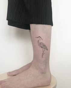 a bird tattoo on the leg of a person