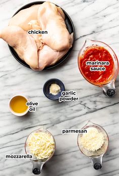 ingredients for marinara sauce laid out on a marble counter top, including parmesan cheese and chicken