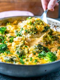 broccoli and cheese casserole being lifted with a spoon from a skillet