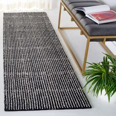 a black and white area rug in a living room next to a bench with a book on it