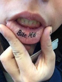 a close up of a person's tongue with the word bite me written on it