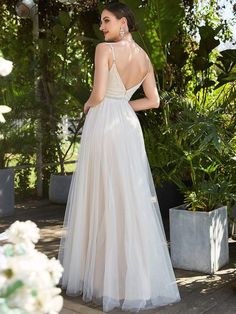 a woman in a white wedding dress standing on steps with her back to the camera