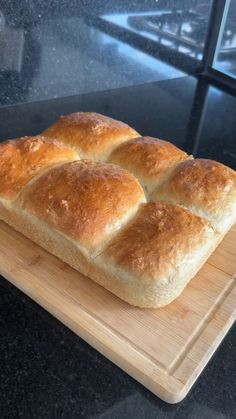 a loaf of bread sitting on top of a wooden cutting board