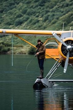 a man standing on the water next to an airplane