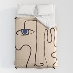 a bed with a white comforter and blue eyes on it