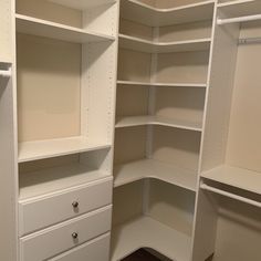 an empty closet with white shelves and drawers