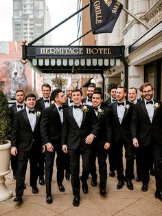 a group of men in tuxedos are posing for a photo outside the hemitage hotel