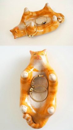 an orange and white cat ring holder with two rings on it's front end