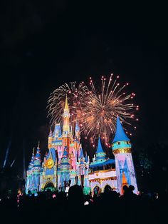 fireworks are lit up in the sky above a castle