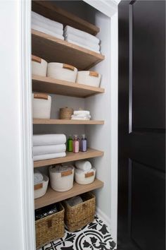 a closet with shelves and baskets filled with white towels, toiletries and other items