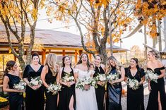 a group of women standing next to each other holding bouquets in their hands and laughing