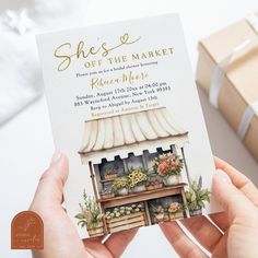 a person holding up a card that says she's off the market place in front of a gift box