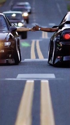 two cars driving down the road with one being pushed by another