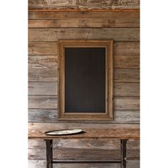 a wooden bench with a chalkboard on it in front of a wood paneled wall