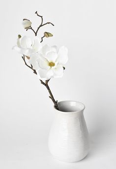 a white vase with some flowers in it