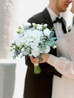 the bride and groom are standing close together