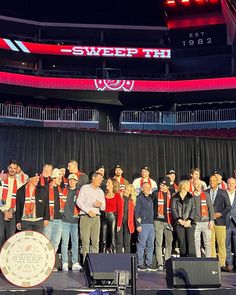 a group of people standing on top of a stage in front of a microphone and banner