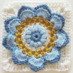 a crocheted square with a flower in the middle on it's side